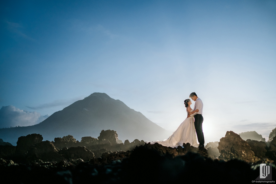 Prewedding in Mountain Batur Bali happy love smile white gown and tuxedo crown sunrise stone larvae mountain