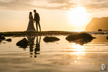 Prewedding in Melasti Beach Bali happy love smile happy sunset romantic hug kiss gray dress and tuxedo cliff